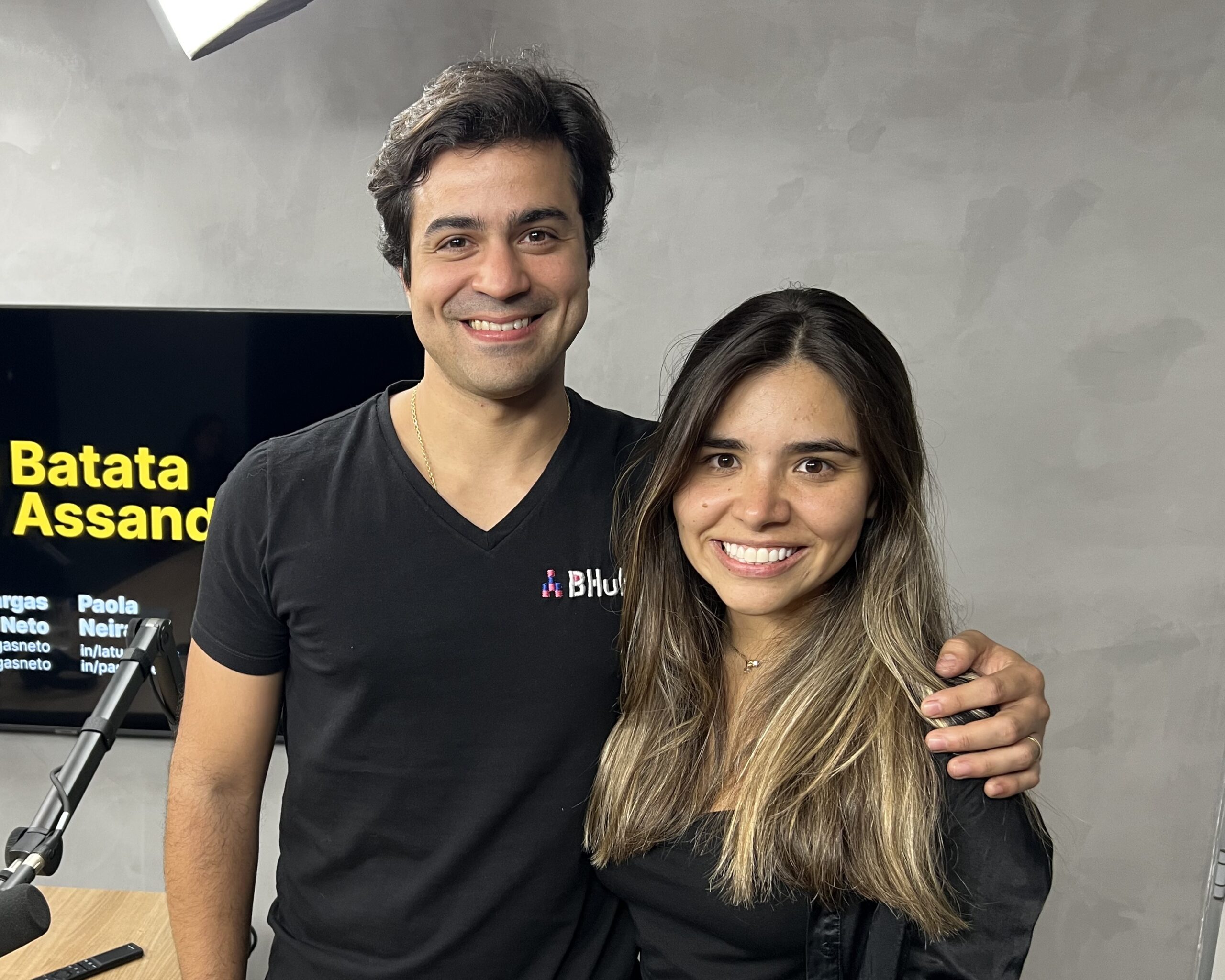 Jorge Vargas Neto e Paola Neira posam para foto dentro de estúdio de podcast para ilustrar texto sobre a participação da executiva no quadro Papo de Empreendedores