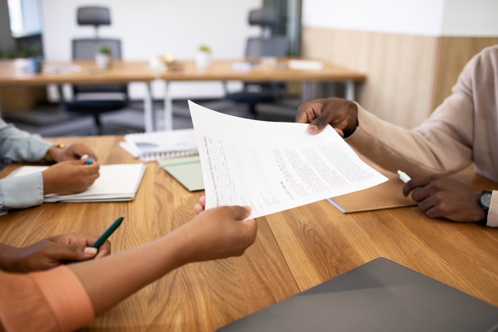 Homem com contrato para seu novo trabalho de escritório após a entrevista para ilustrar, dessa forma, artigo sobre como a terceirização de serviços de paralegal pode contribuir para a conformidade legal da empresa