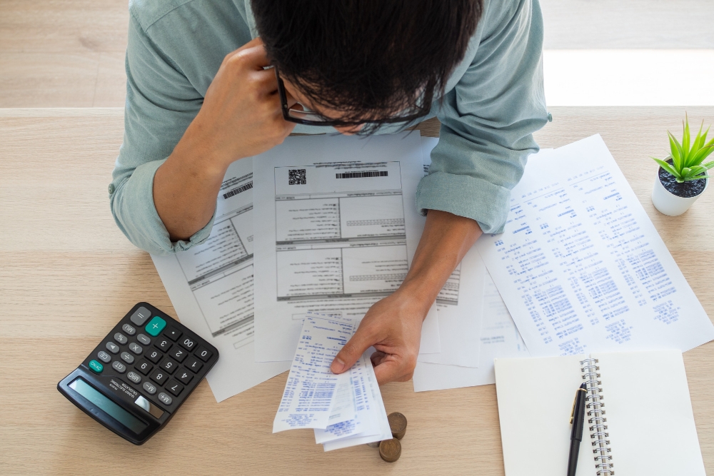 Foto empresário com preocupações financeiras para ilustrar assim artigo sobre motivos pelos quais a emissão manual de nota fiscal pode custar caro para seu negócio