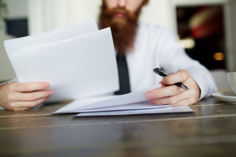 Homem lendo documentos comerciais para ilustrar artigo sobre como Legal Ops pode aumentar seus lucros