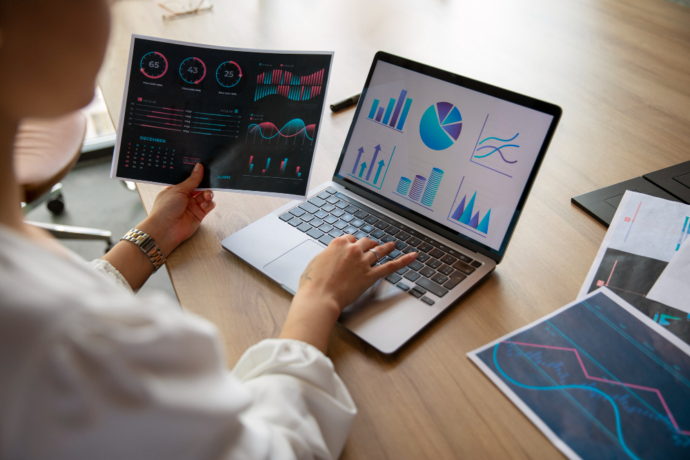 Foto trabalhadores de escritório usando gráficos de finanças para ilustrar assim artigo sobre como escolher o software de gestão financeira certo para seu negócio