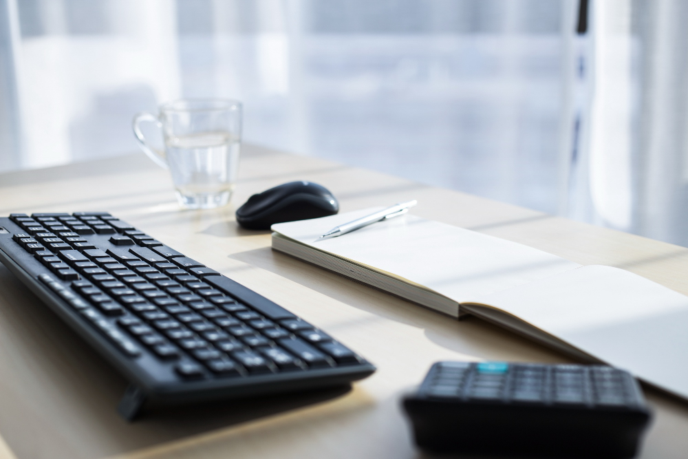 local de trabalho com teclado, mouse, calculadora e caneta para ilustrar assim artigo sobre as vantagens do BPO financeiro para escritórios de contabilidade