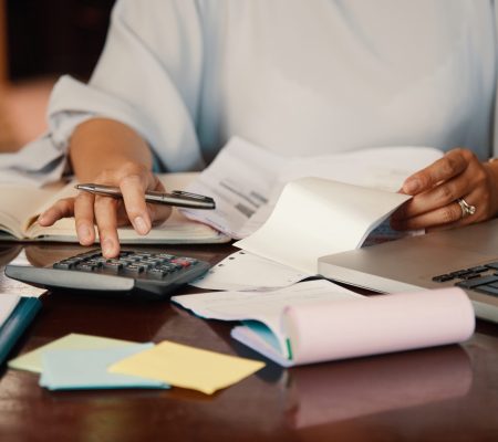 Hands of female entrepreneur working with bills and documents